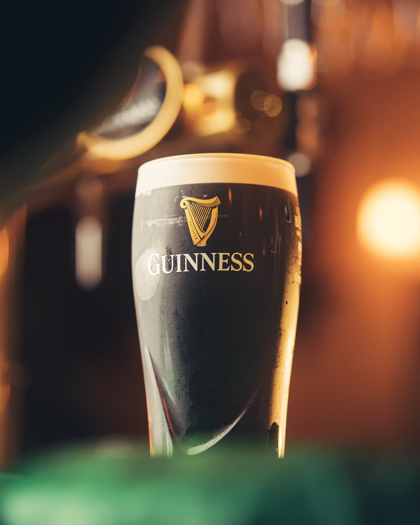 A pint of Guinness on the bar under the tap